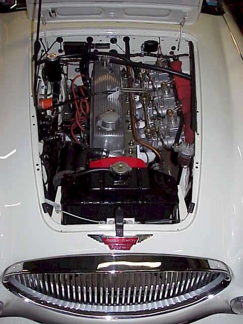 Triple webers and LYNX rocker cover have been fitted to the black & white Healey since 1969